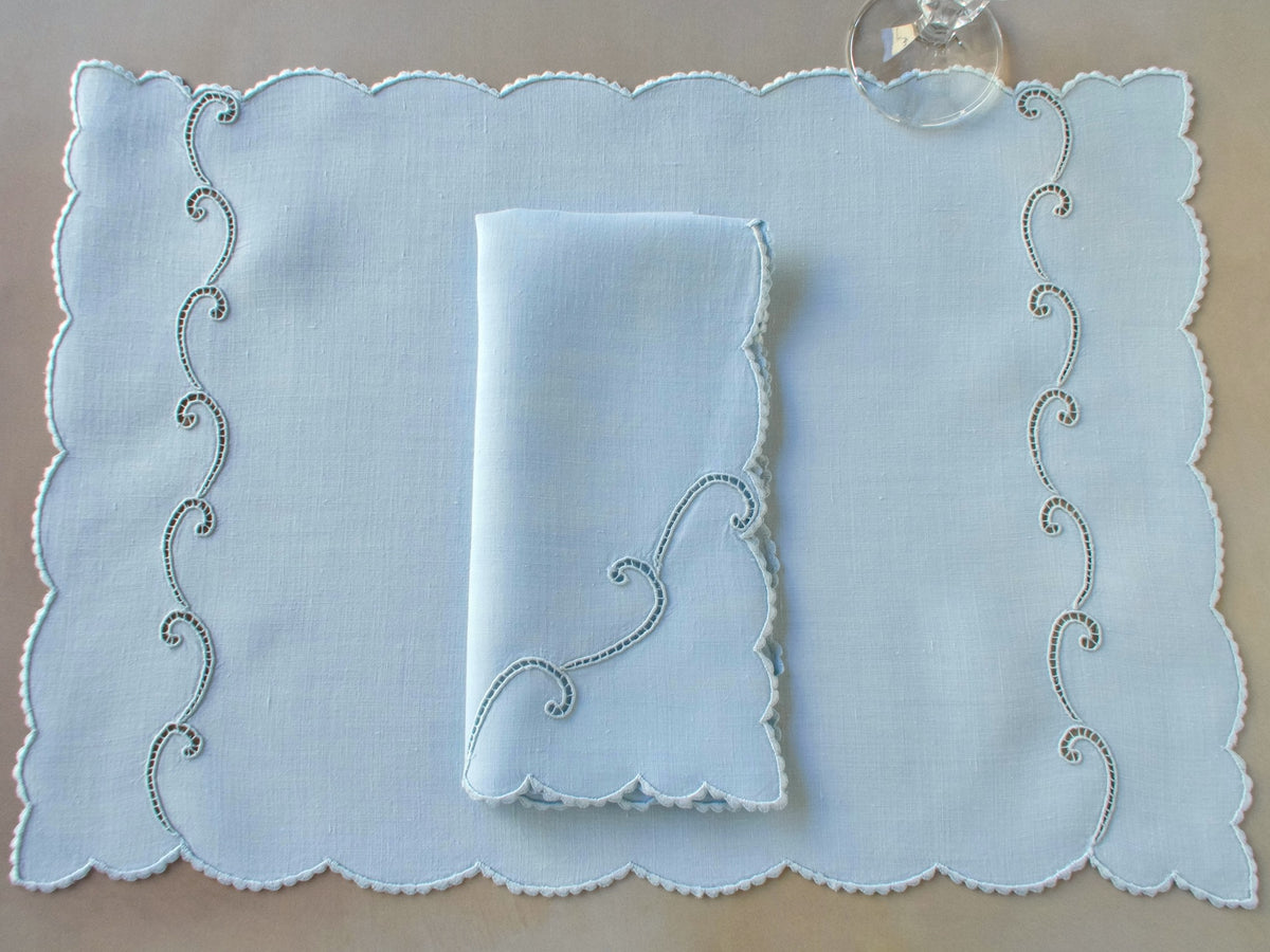 Blue Marghab “Simplicity” placemat and napkin set with scrolling cutwork and caseado bastido edging, embroidered on fine linen, handmade in Madeira.