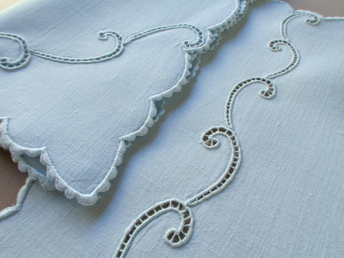 Blue Marghab “Simplicity” placemat and napkin set with scrolling cutwork and caseado bastido edging, embroidered on fine linen, handmade in Madeira.