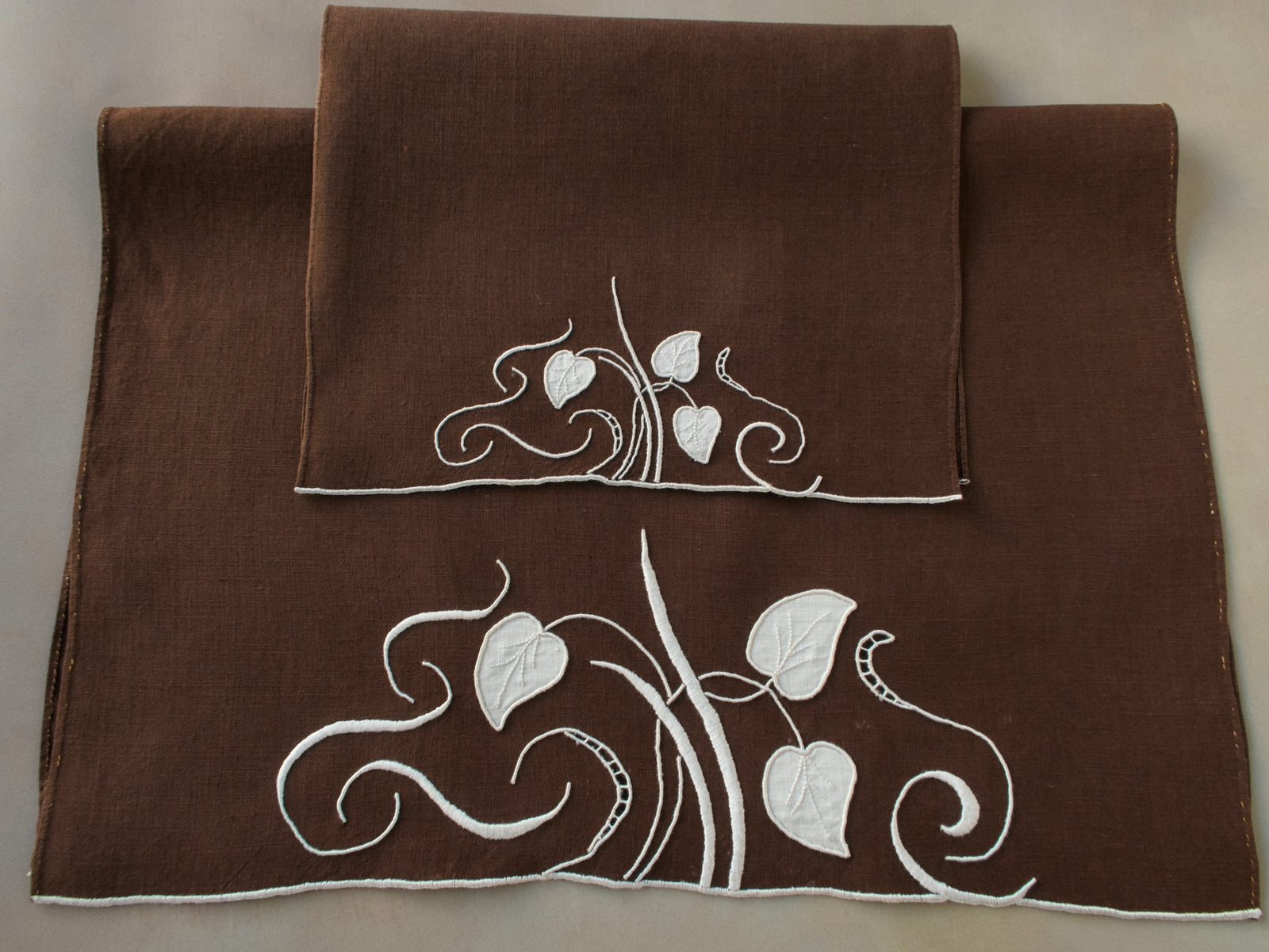 Marghab linen towels in the “Water Leaf” pattern, hand embroidered in brown on fine linen — guest and fingertip sizes shown together.