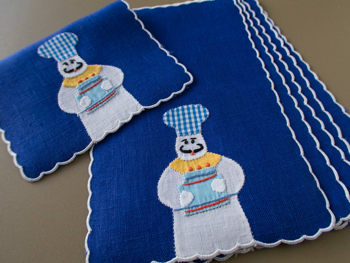 Stack of vintage Madeira cocktail napkins with appliqué bakers and scalloped edges