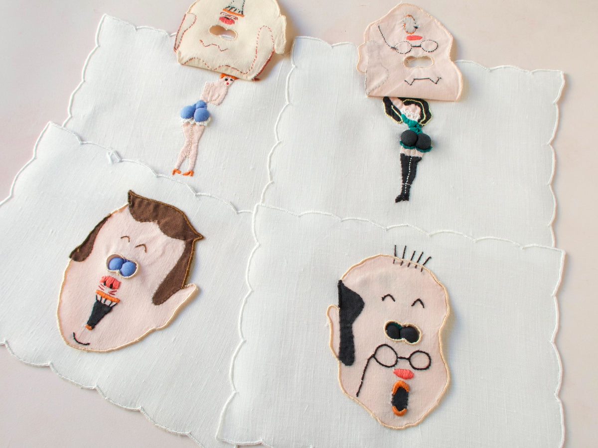 Vintage Madeira peek-a-boo cocktail napkins featuring embroidered men’s faces with padded ‘eyes’ that lift to reveal playful pin-up figures underneath. 