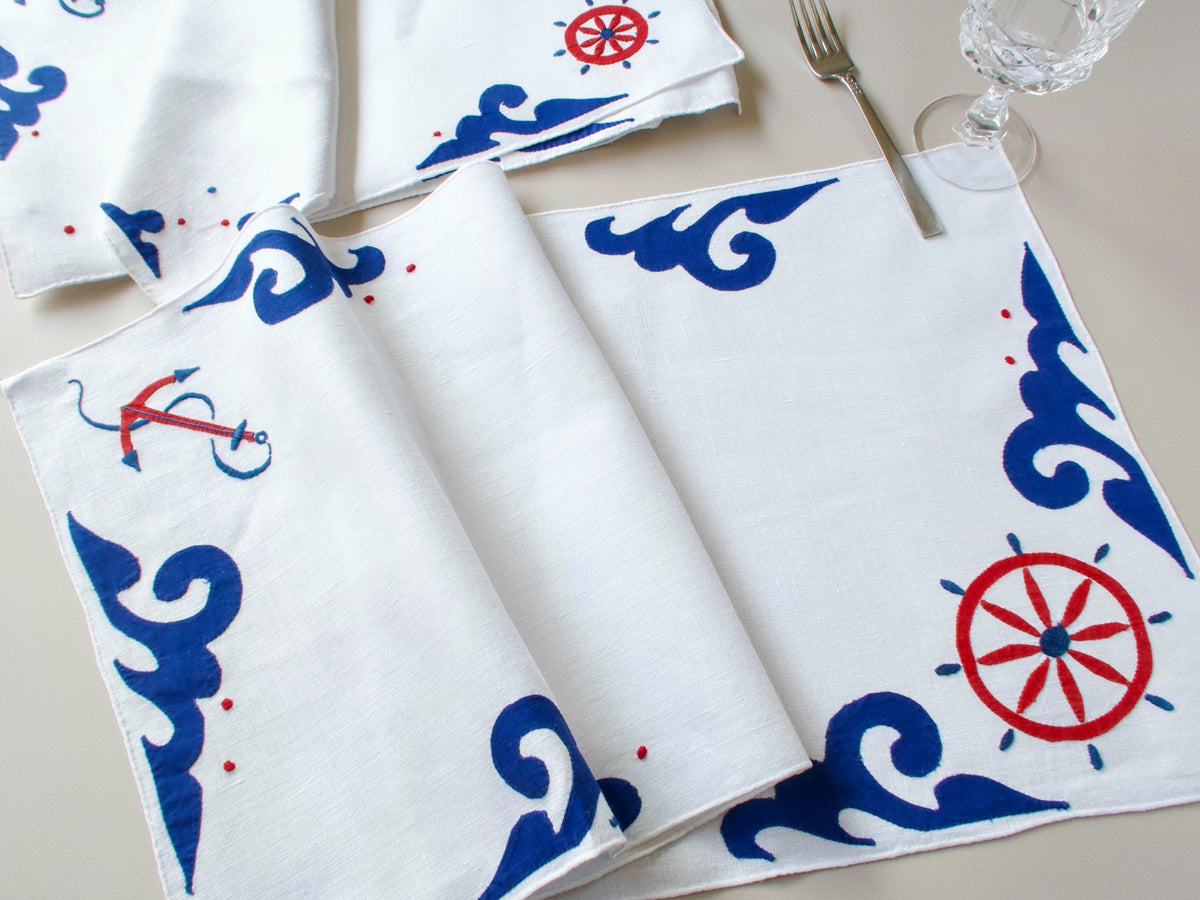 Vintage Italian nautical table runner with hand embroidered anchors, ship’s wheels and waves in navy and red on white linen.​​​​​​​​​​​​​​​​