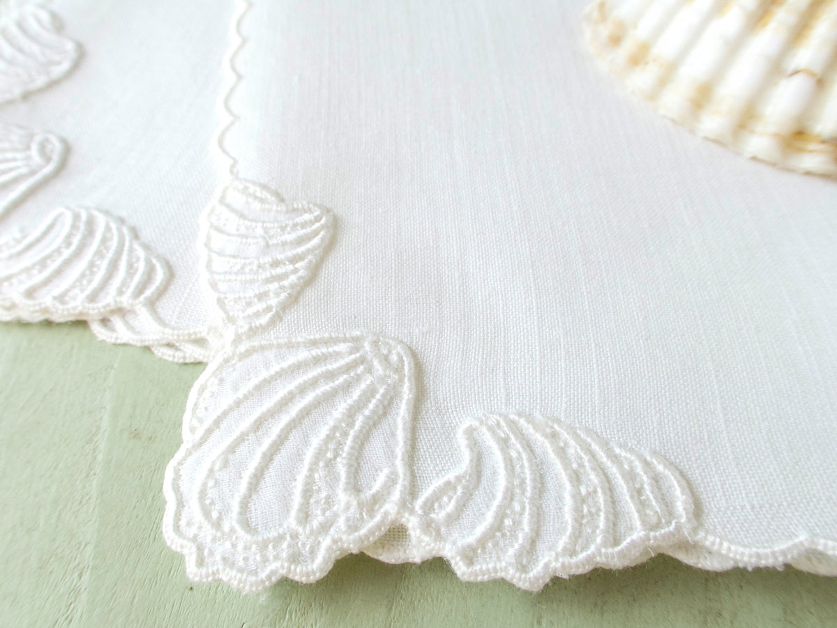 Close view of raised white shell embroidery on vintage Madeira Irish linen cocktail napkin, dense dimensional handwork.
