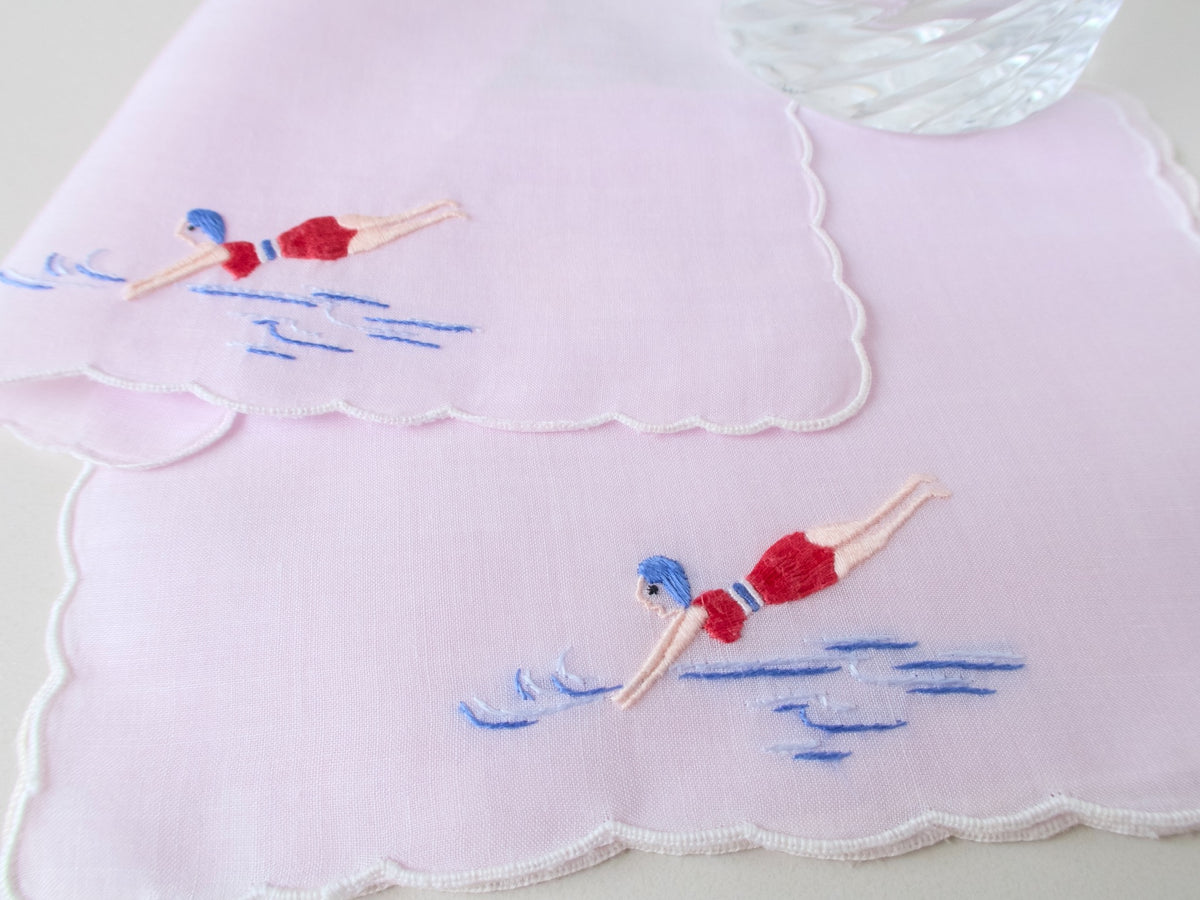 Vintage hand embroidered cocktail napkins, set of 6, with retro swimmer motif in red and blue on white cotton, scalloped edges.