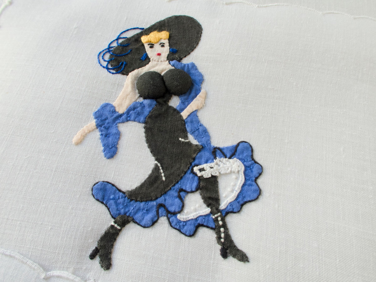 Vintage Madeira linen cocktail napkin by Paragon, featuring a playful hand-embroidered lady with dimensional appliqué and bright color
