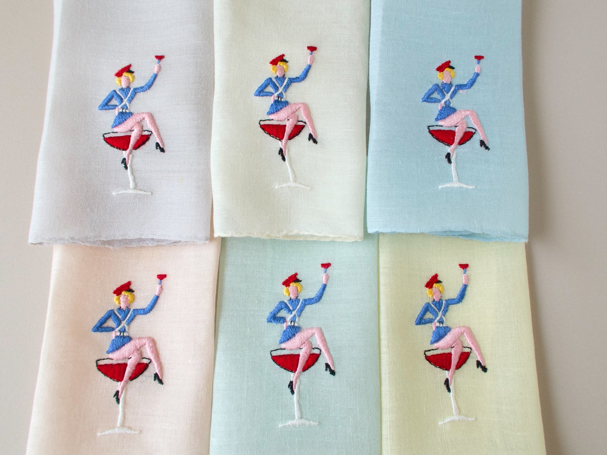 Vintage Italian hand embroidered cocktail napkins, set of 6, showing jaunty sailor figure with raised cocktail glass on semi-sheer pastel linen.