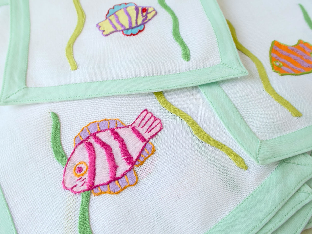 Vintage Léron cocktail napkins, set of 6, colorful tropical fish hand appliquéd on semi-sheer linen with celadon green border, each napkin a different colorway.