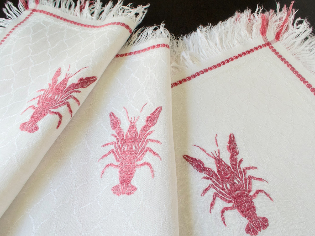 Three antique French lobster damask napkins fanned showing different crustacean motifs