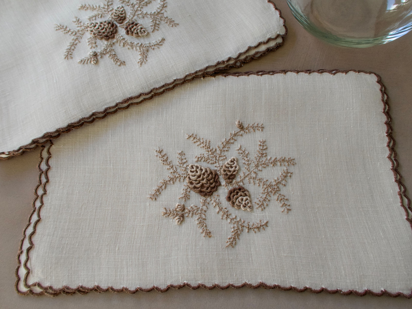 Vintage Marghab cocktail napkins in the “Pine Cones” pattern on fine linen, hand embroidered in Madeira with raised pinecone motifs and a scalloped edge.