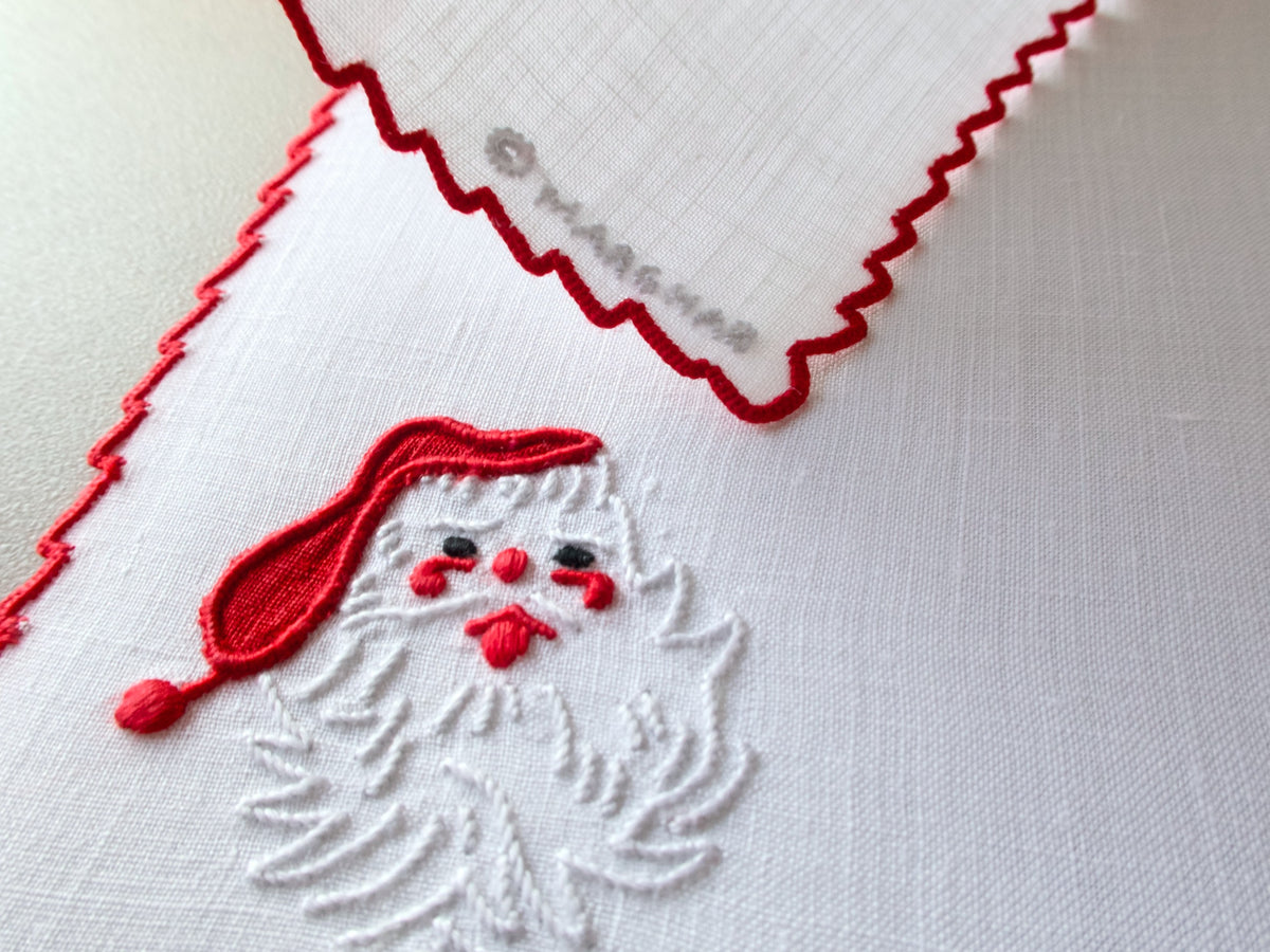 Detail of Marghab “Papa Noel” embroidered Santa motif in red and white thread on fine linen with scalloped border.