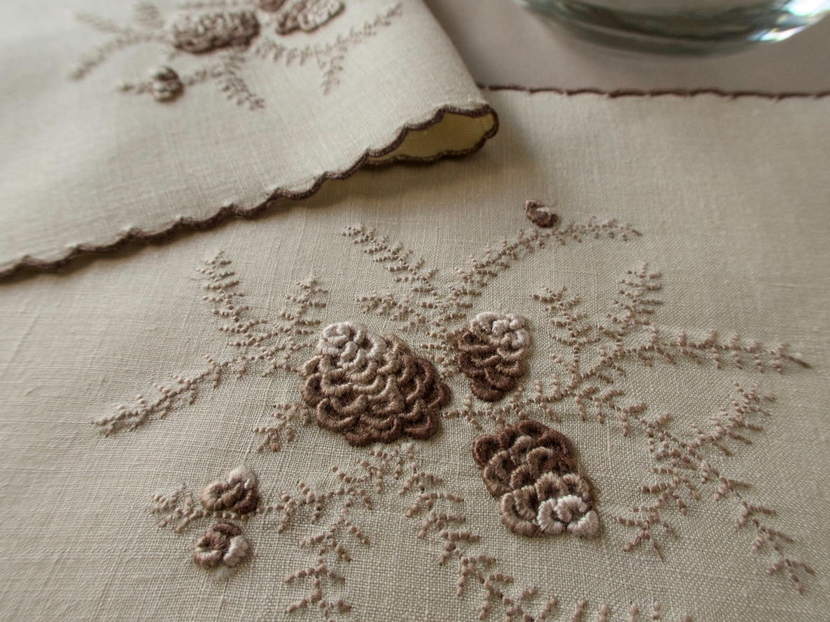 Close shot of Marghab&#39;s &quot;Pines Cones&quot; pattern, embroidery on linen cocktail napkin, Madeira handwork.