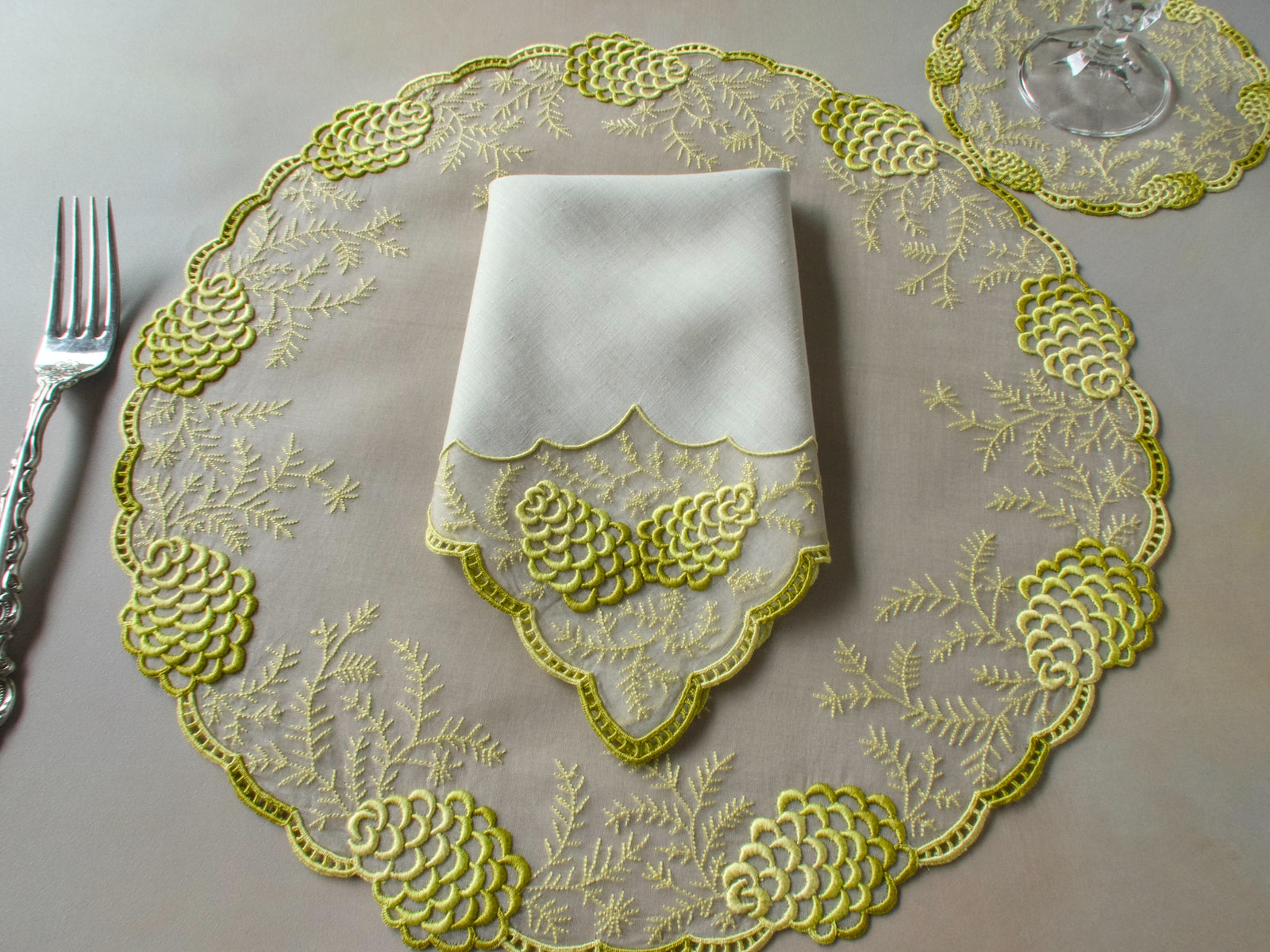 Vintage Marghab "Pine Cones" placemat with napkin folded in the center, pine cone motifs around the border