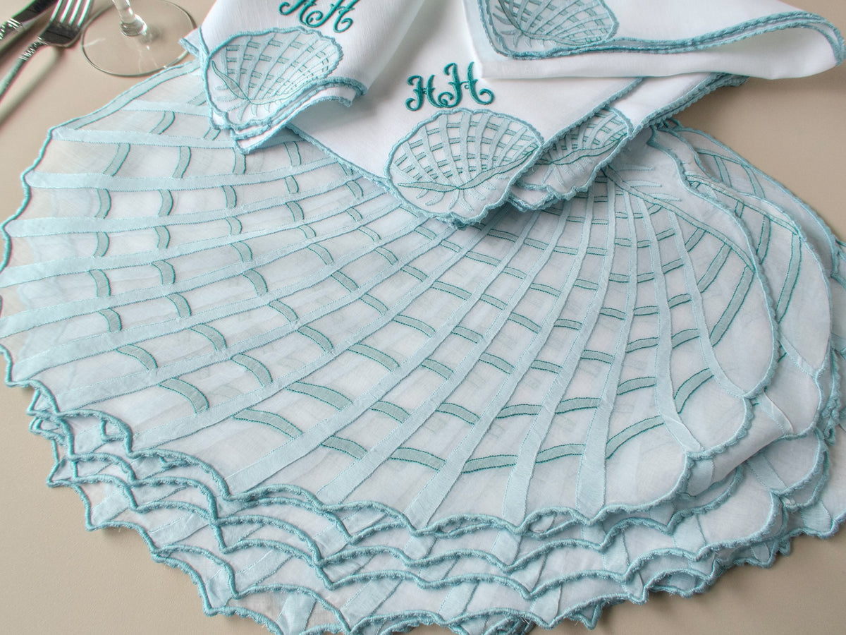 Stacked vintage Léron organdy placemats with draped monogrammed napkin, showing scale and caseado bastido edge detail​​​​​​​​​​​​​​​​