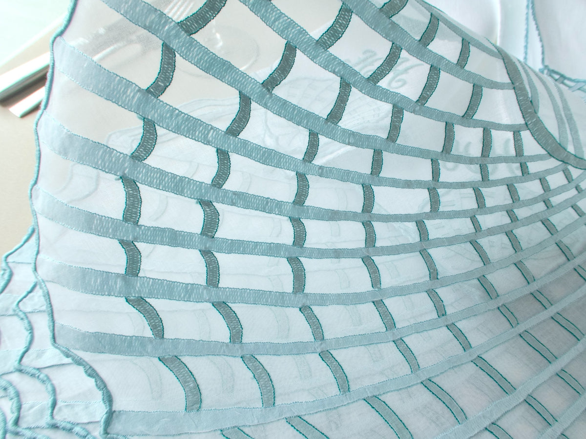 Close-up of dense Madeira shadow work embroidery on organdy, showing shell pattern and caseado bastido edging detail