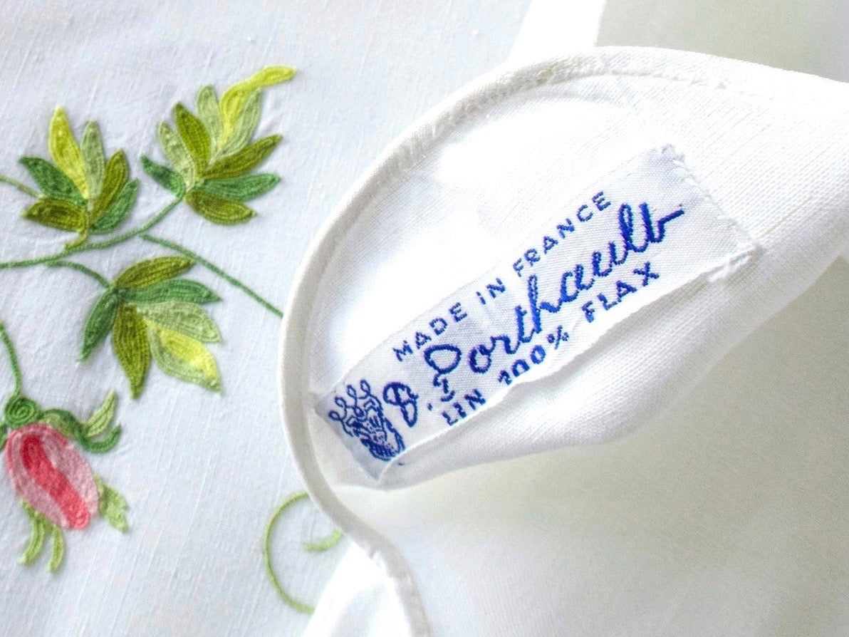 D. Porthault label reading Made in France, Lin 100% Flax beside Beauvais embroidered roses on white linen