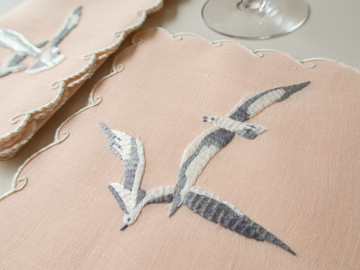 Close view of vintage Madeira hand embroidered seagulls, grey and white feather shading on coral Irish linen, extraordinary detail.