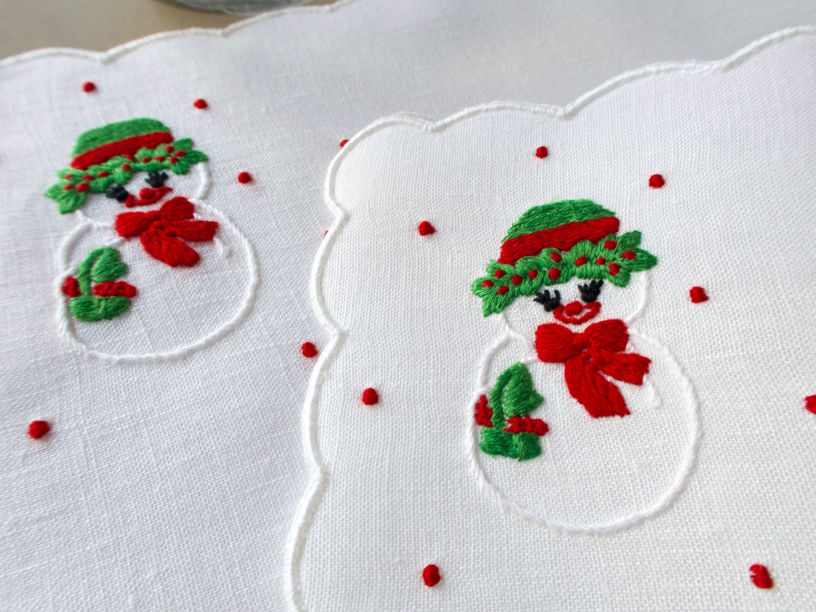 Snow-lady embroidery on white scalloped linen cocktail napkins, hand embroidered in Madeira.