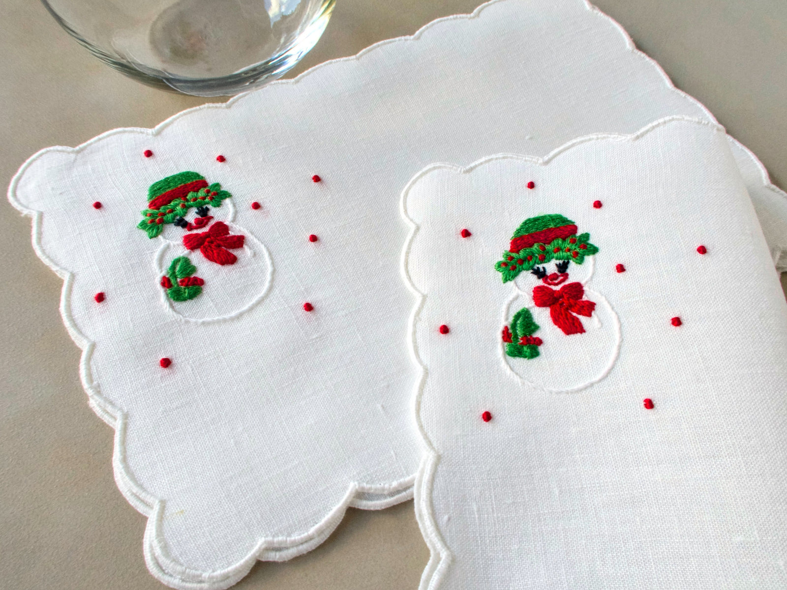 Snow-lady embroidery on white scalloped linen cocktail napkins, hand embroidered in Madeira.