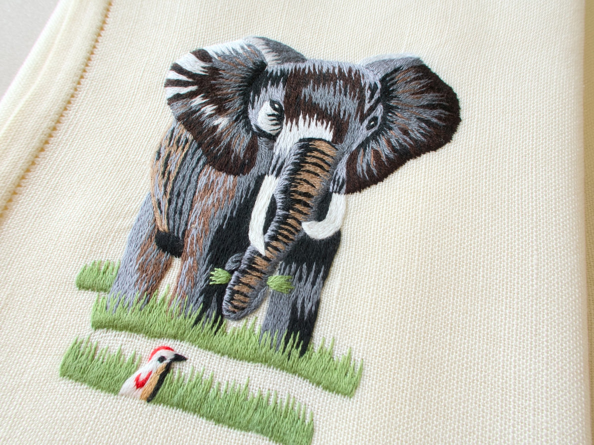 Close-up of vintage hand embroidered placemat showing elephant with detailed naturalistic embroidery on linen
