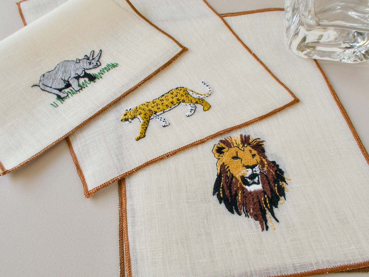  Close-up of vintage cocktail napkins, dramatic embroidered lion head with full mane on ecru linen