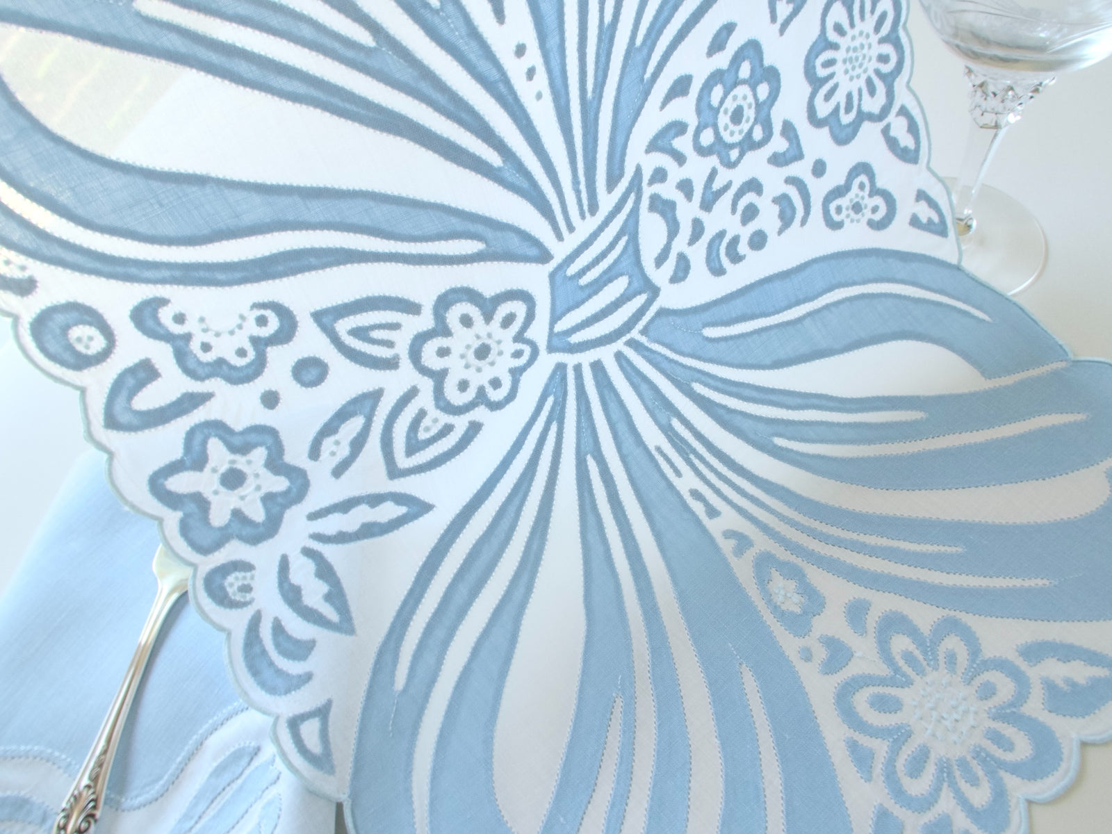 Detail of blue bow in embroidery and applique, vintage Madeira hand embroidered placemat set.