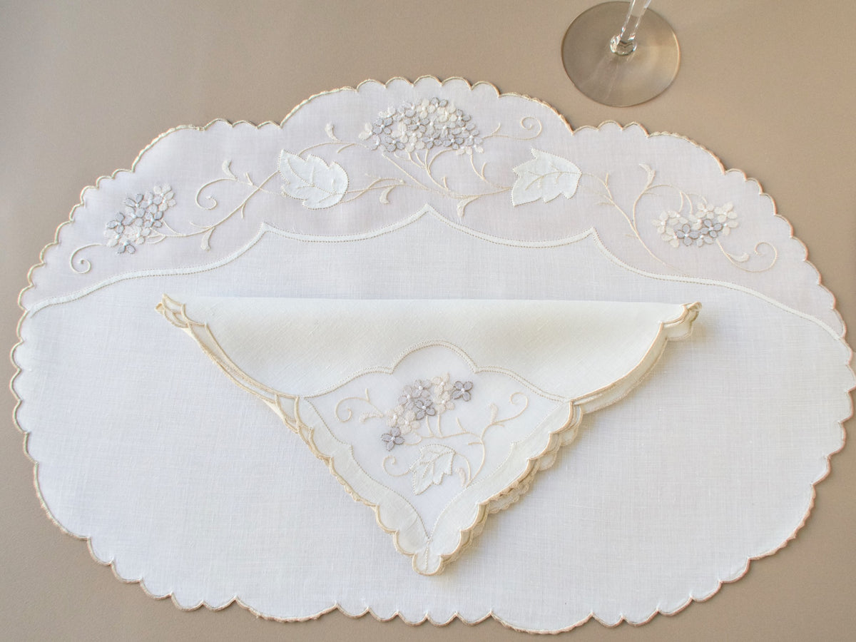 Vintage Madeira oval placemat and folded napkin, ivory linen and organdy with tone on tone hydrangea clusters and scrolling vine embroidery, scalloped edges