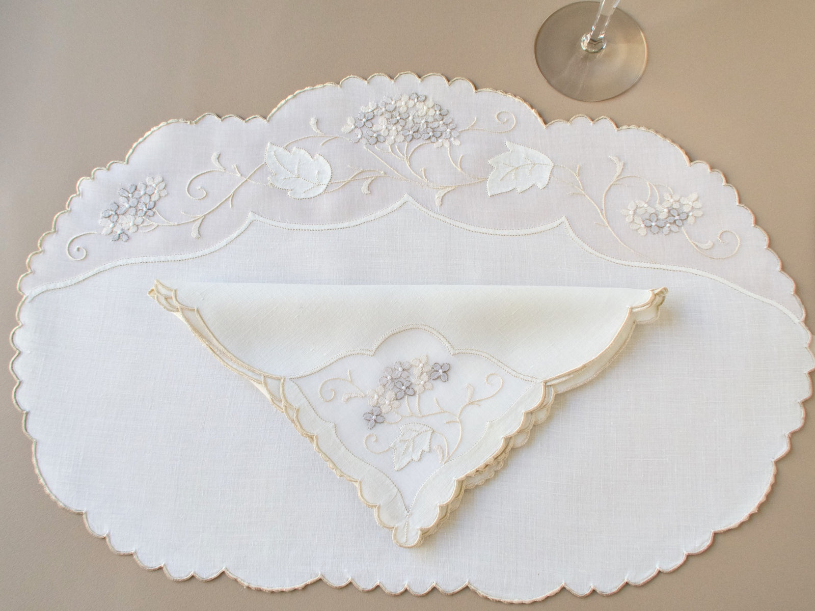 Vintage Madeira oval placemat and folded napkin, ivory linen and organdy with tone on tone hydrangea clusters and scrolling vine embroidery, scalloped edges