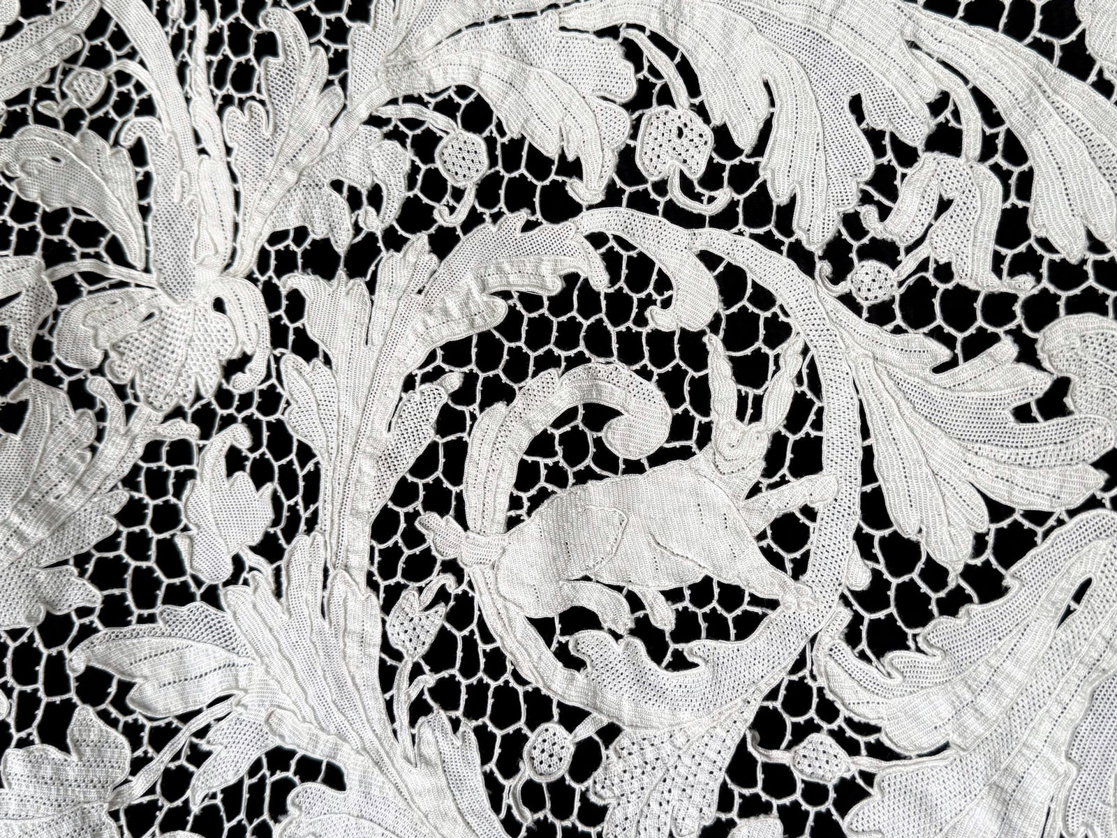 Rabbit leaping through leafy scrollwork in a close view of the lace.