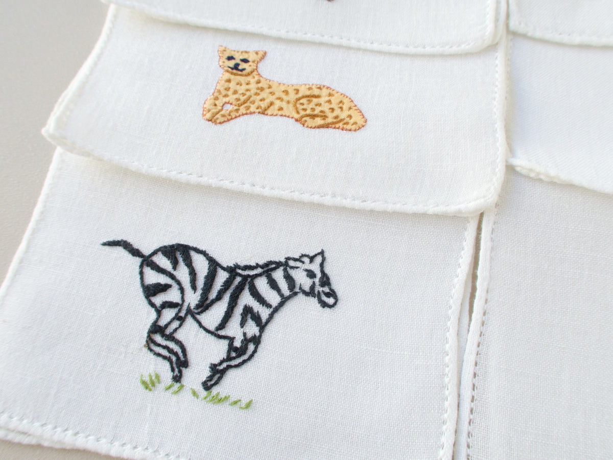 Close-up of vintage Italian cocktail napkin, embroidered running zebra on white semi-sheer linen
