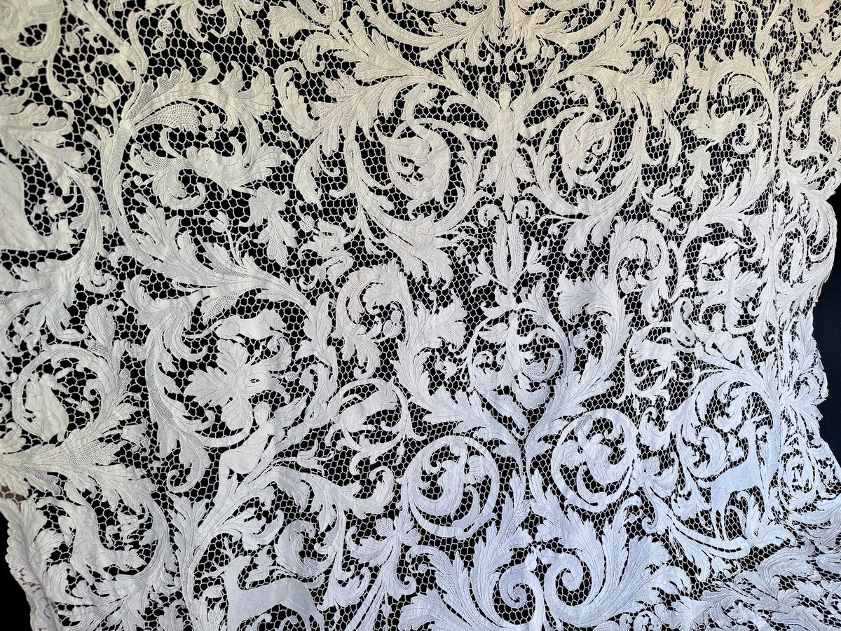 Broad view of the tablecloth’s dense floral and figural lacework.