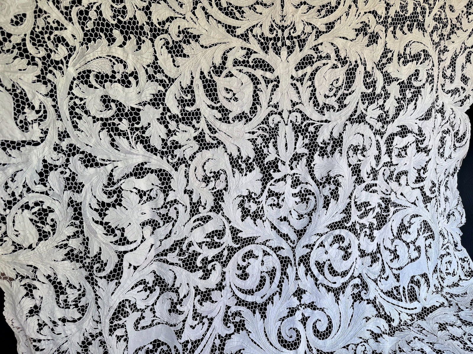 Broad view of the tablecloth’s dense floral and figural lacework.