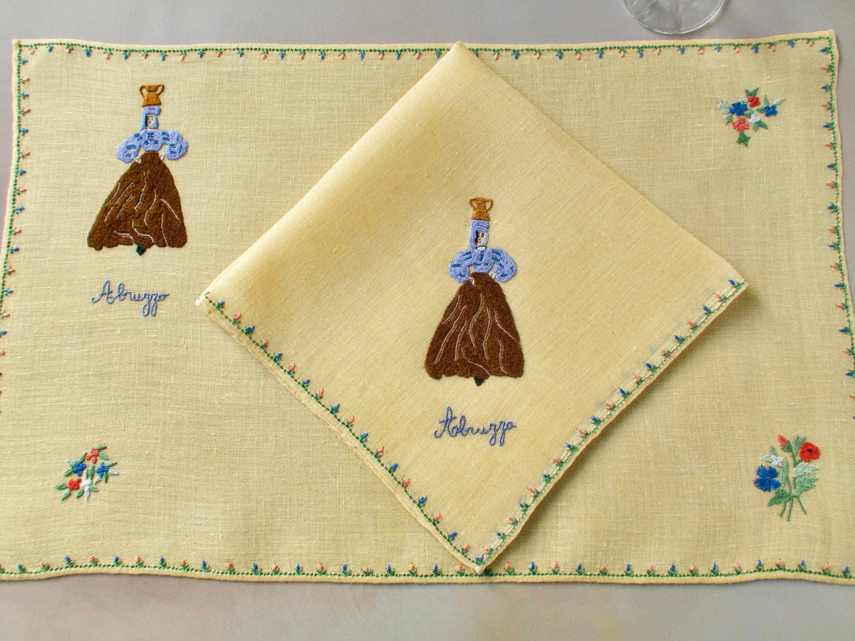 Rapisardi yellow linen placemat with embroidered Abruzzo figure and floral details