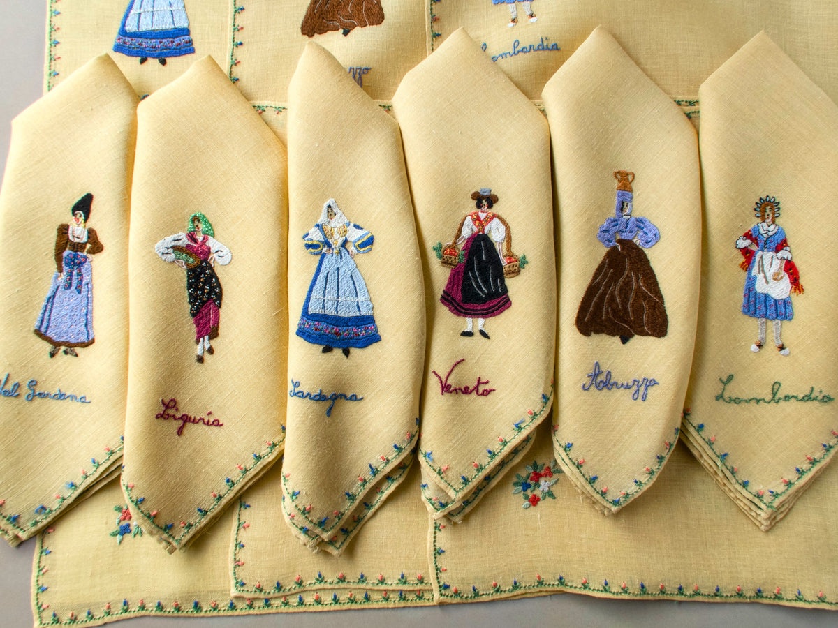 Set of Rapisardi yellow linen placemats showing multiple regional costume figures