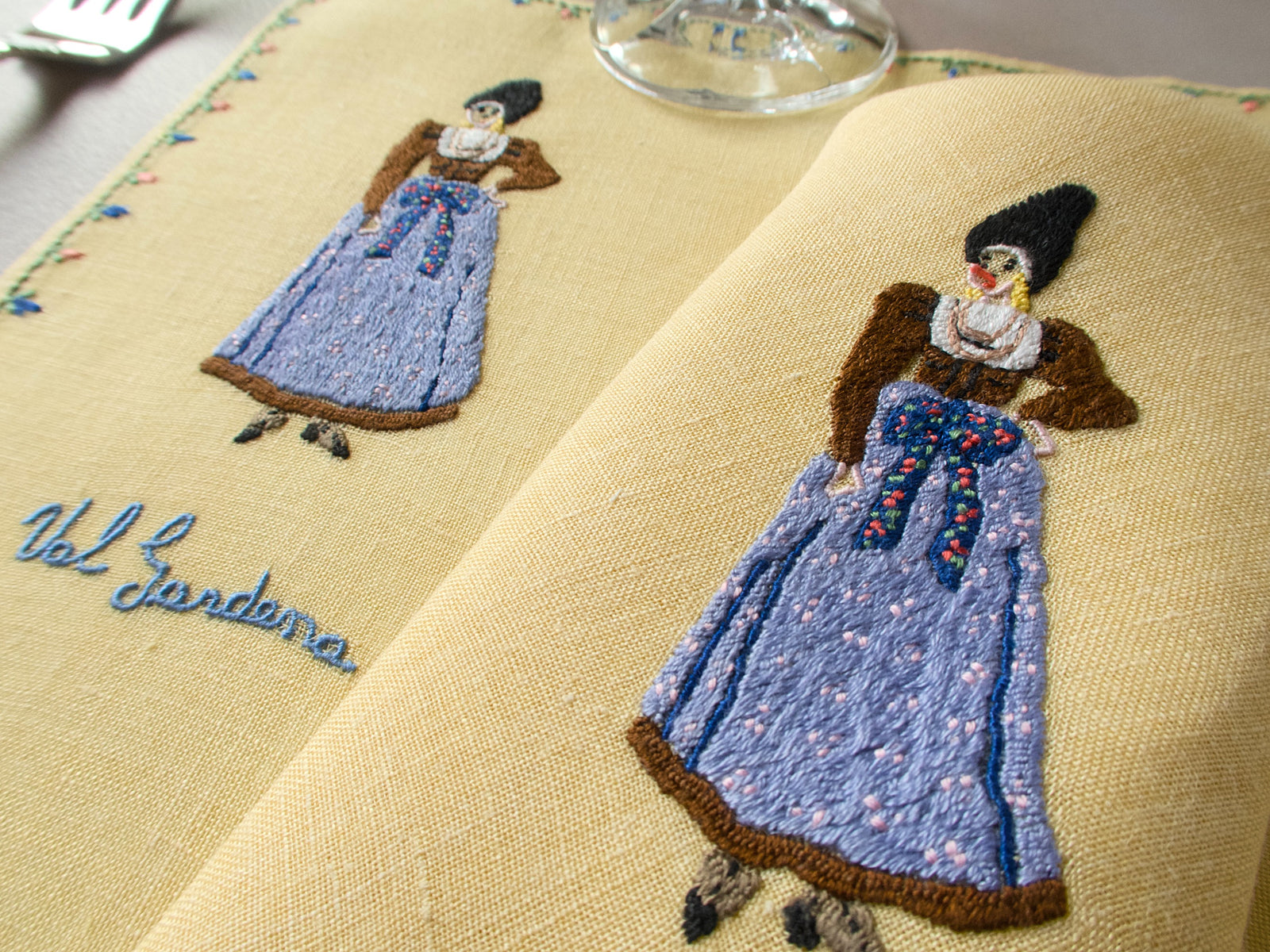 Rapisardi placemat showing embroidered female figure in blue dress