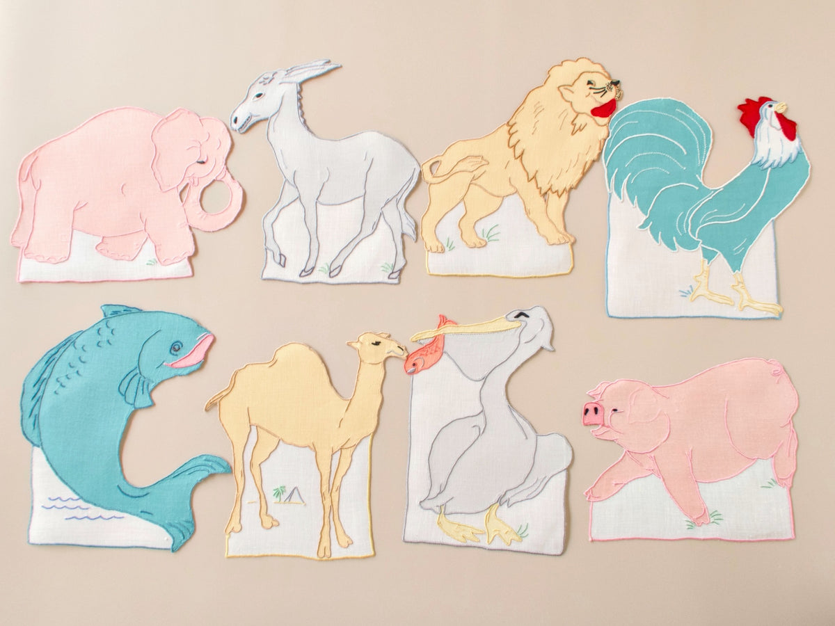 All 8 vintage Madeira cocktail napkins arranged together, hand embroidered animal silhouettes, set of 8