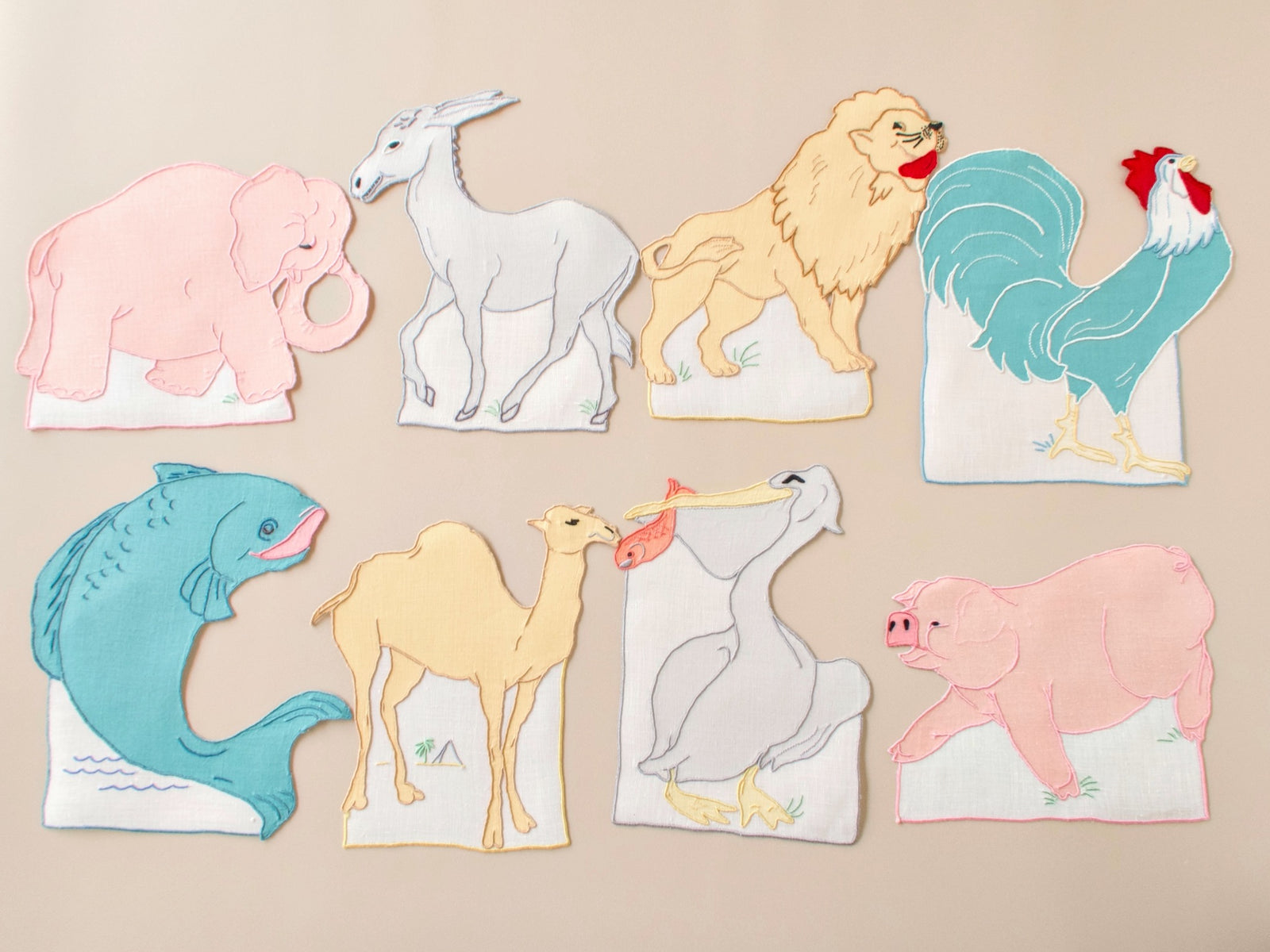 All 8 vintage Madeira cocktail napkins arranged together, hand embroidered animal silhouettes, set of 8