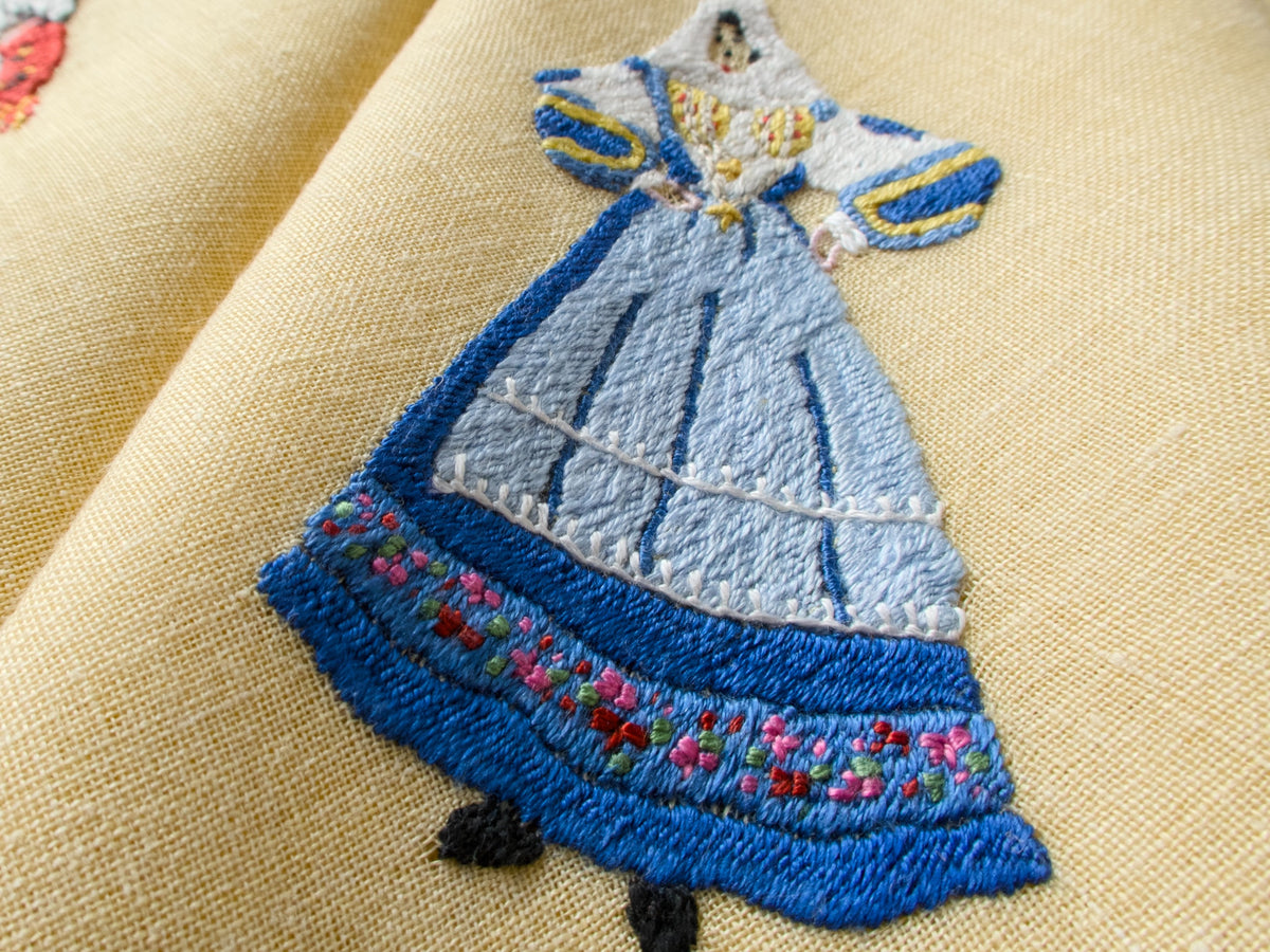 Rapisardi placemat showing embroidered female figure in blue dress