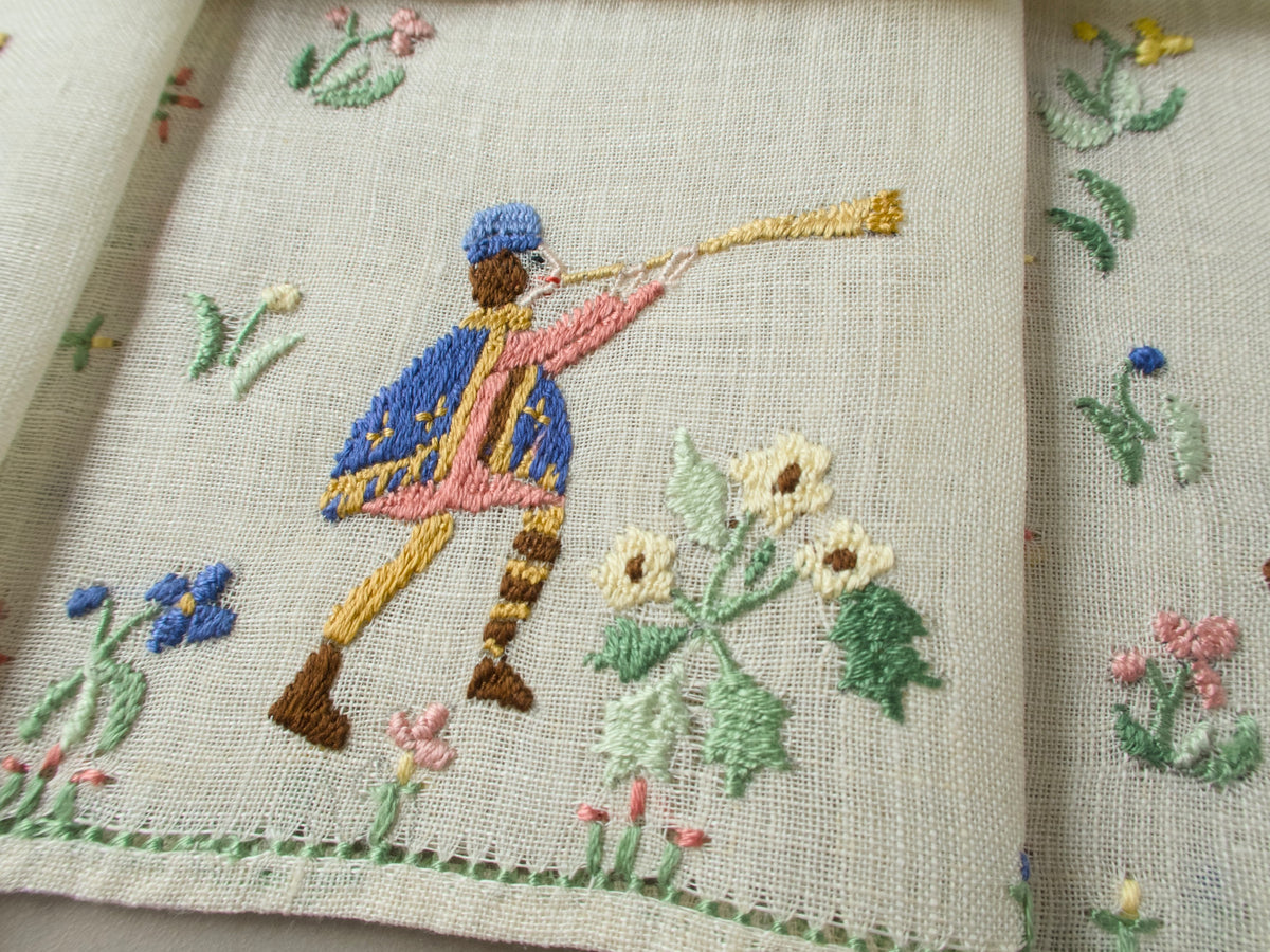  Close-up of a trumpet-playing musician on a cocktail napkin with stitched flowers.