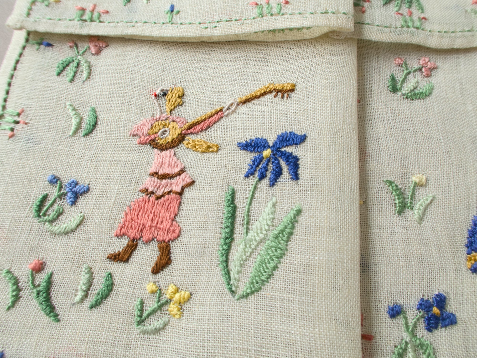 Close-up of a dancing female musician with pink dress on embroidered linen.