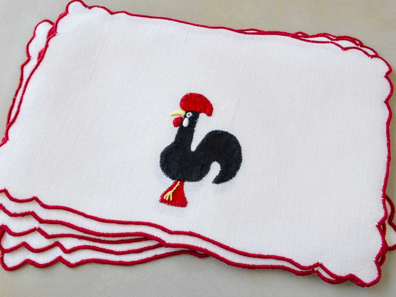 Vintage Madeira cocktail napkins, white linen with red scalloped border, black appliqué Barcelos rooster with red comb and feet