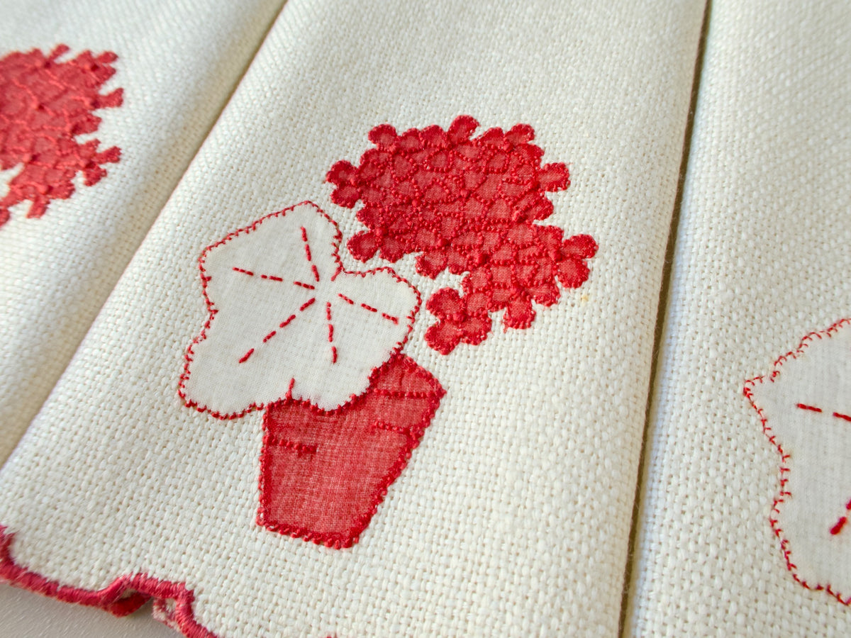 Vintage Marghab marcasual linen fingertip towel showing the “Geranium” design with raised red blooms above a white appliqué leaf and red pot