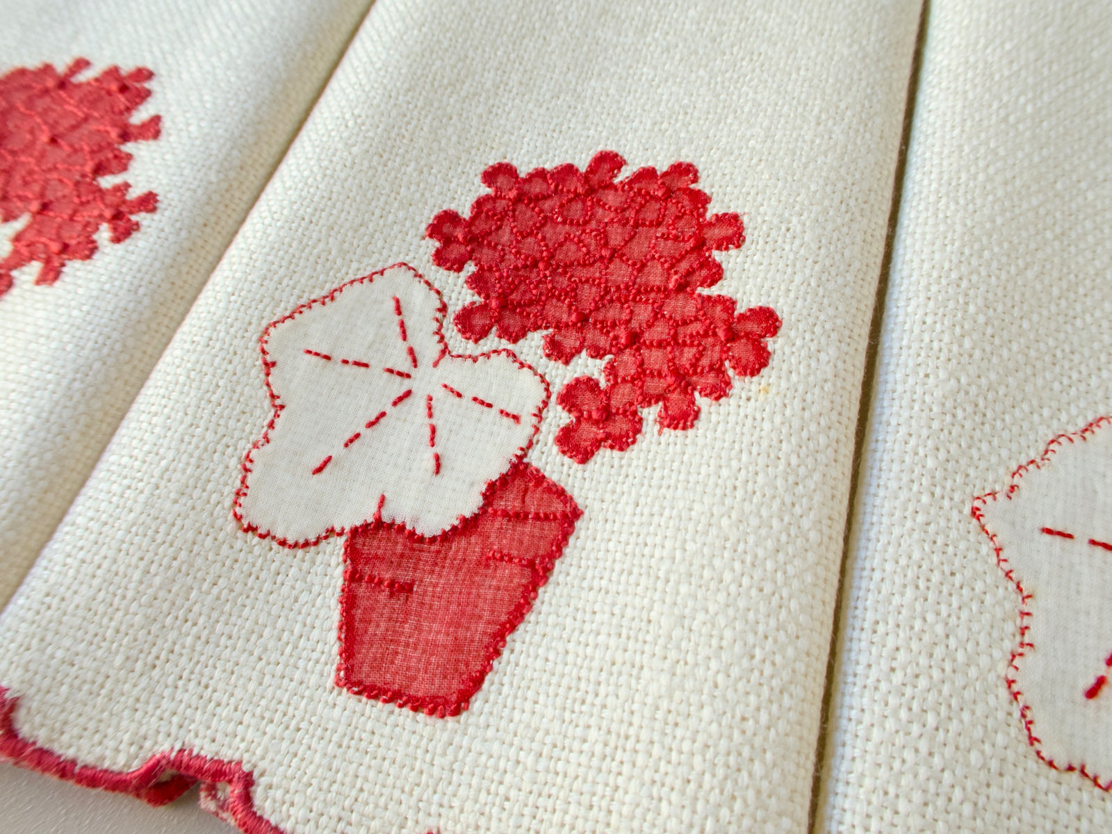 Vintage Marghab marcasual linen fingertip towel showing the “Geranium” design with raised red blooms above a white appliqué leaf and red pot