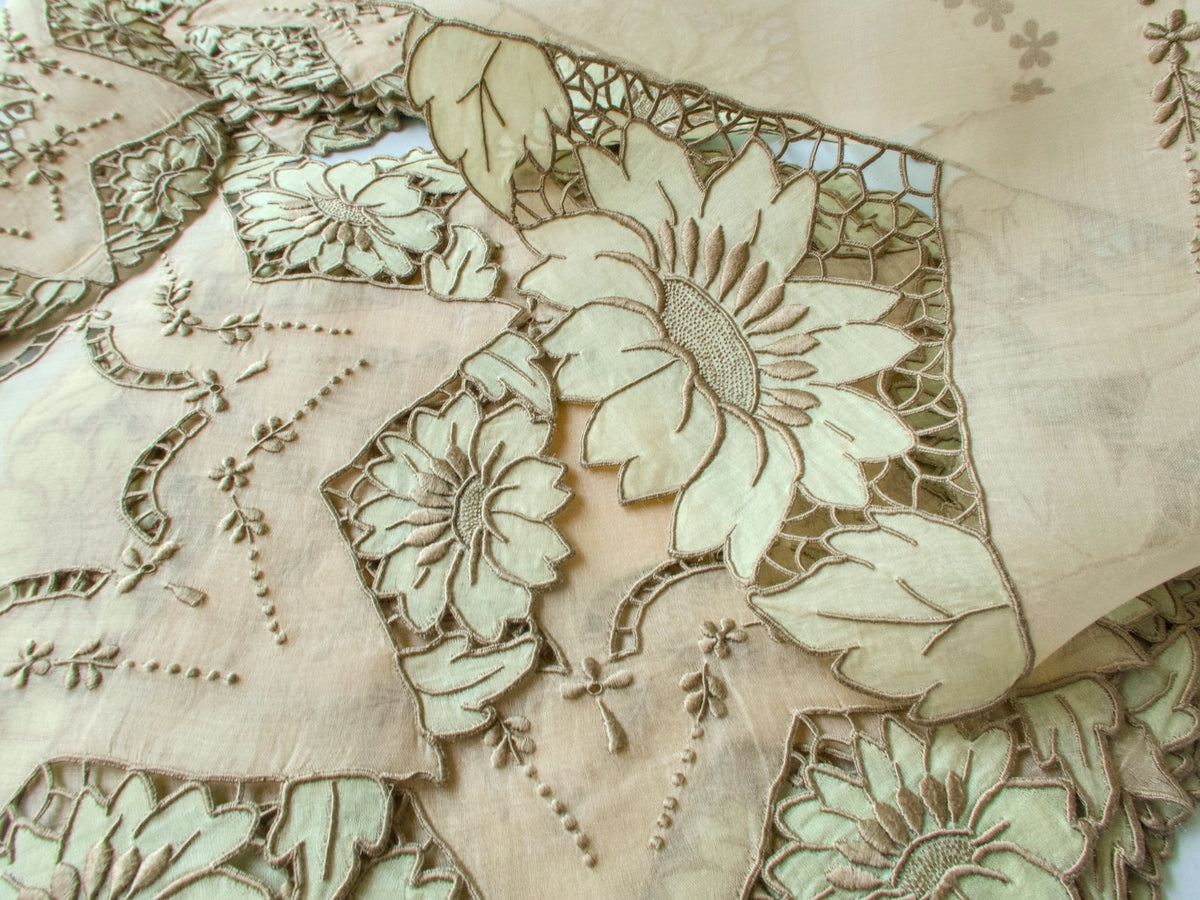 Close-up of sage green sunflower appliqué on vintage Madeira organdy showing embroidery texture and color