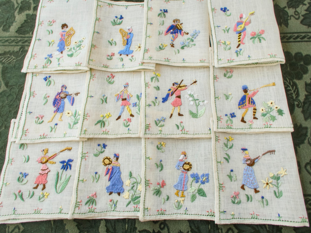 Full layout of all twelve Rapisardi medieval musician napkins arranged in a grid.