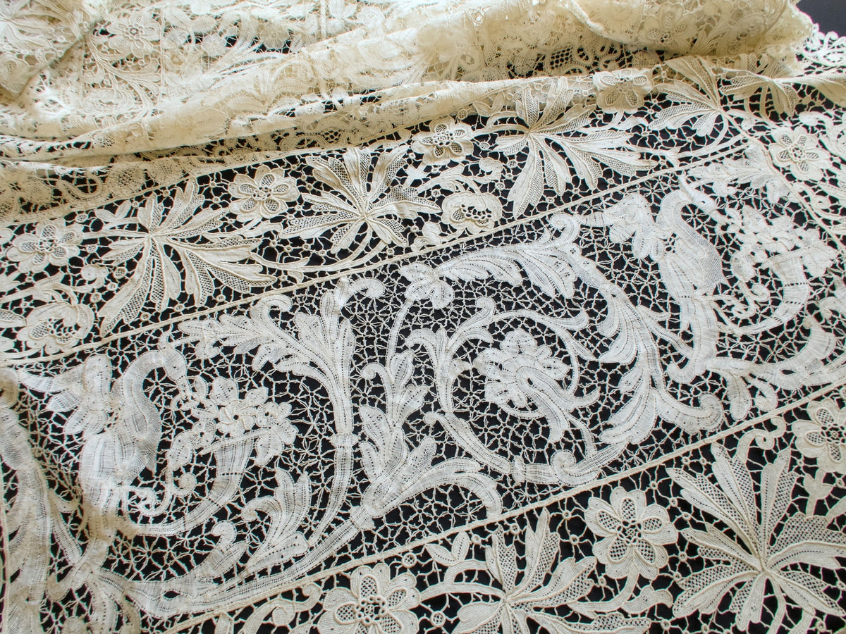 Antique French mixed lace tablecloth corner with a crane panel, floral medallions and a scalloped lace border