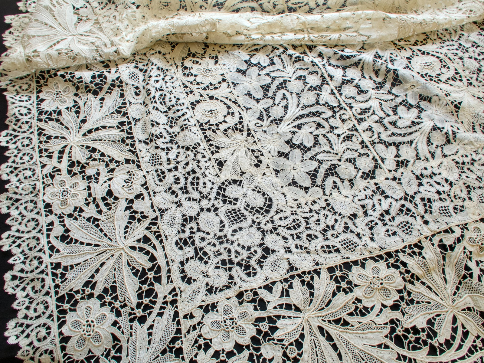 Handmade point de Venise and bobbin lace panels joined by lace bars along a scalloped border on an antique French tablecloth