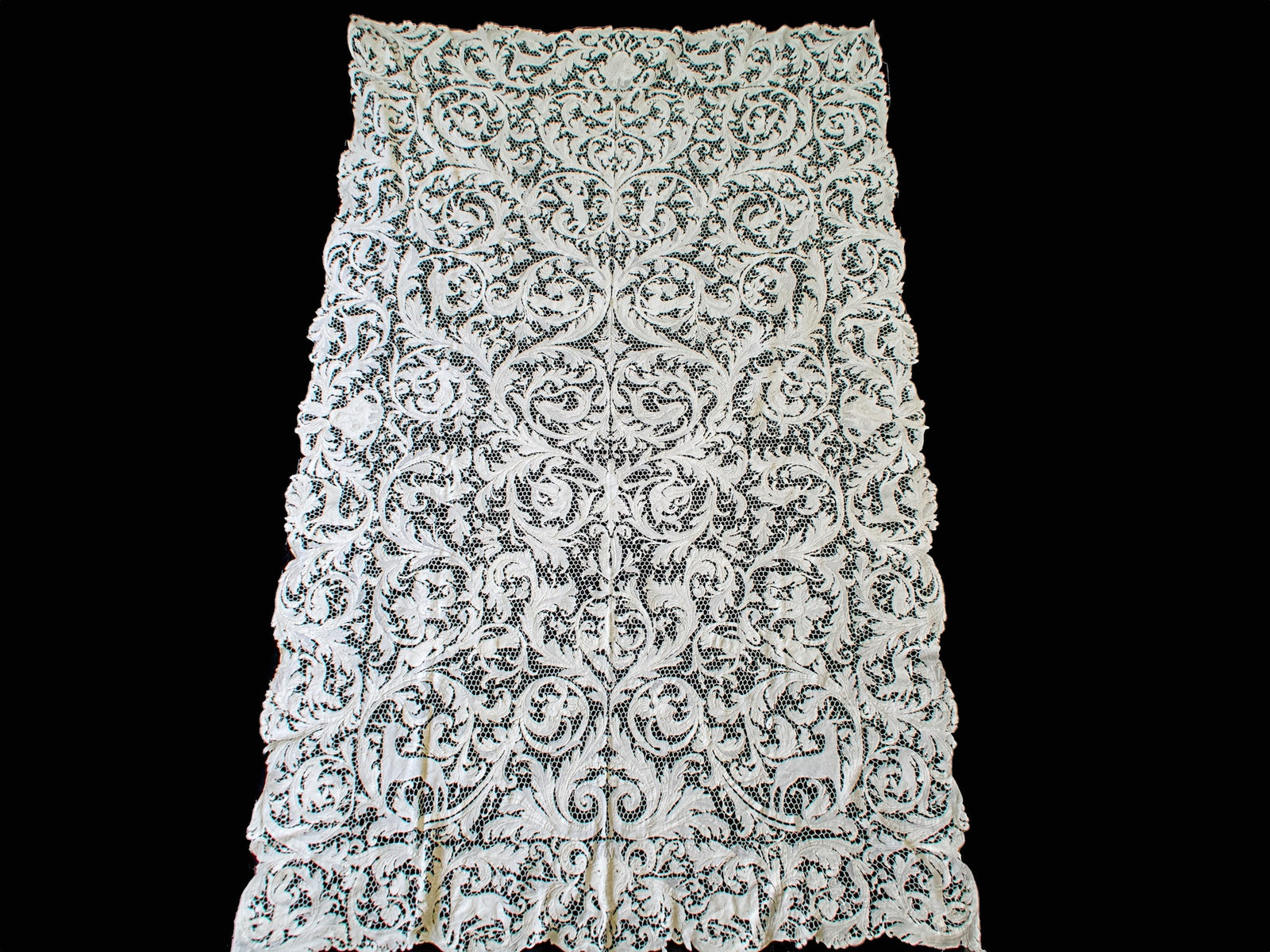 Full view of the rectangular lace tablecloth showing its repeating figural design.