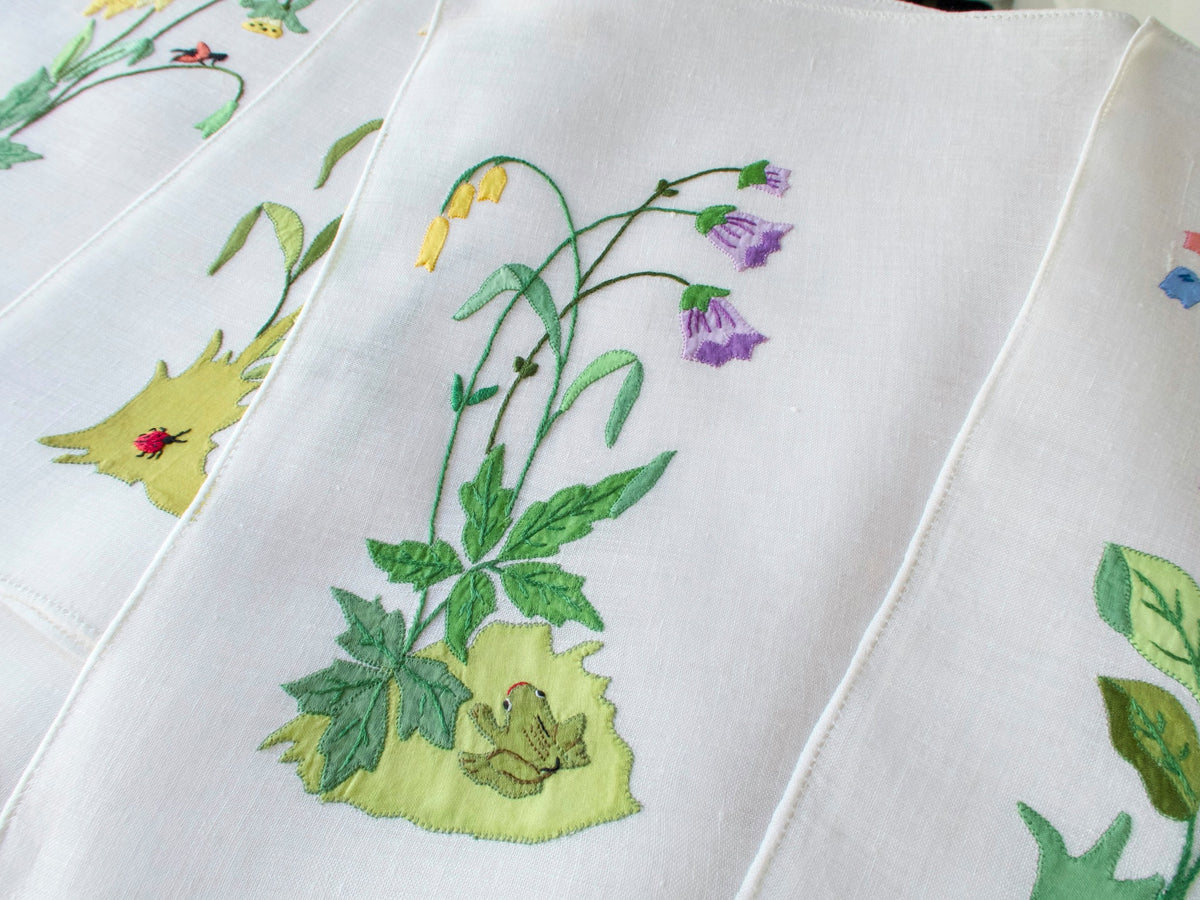 Vintage Italian linen placemat showing hand embroidered frog among flowers and leaves