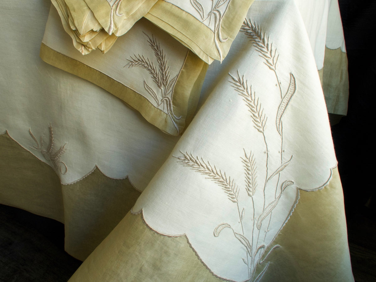Marghab Wheat tablecloth hand-embroidered in Madeira, showing graceful wheat motifs across fine linen.