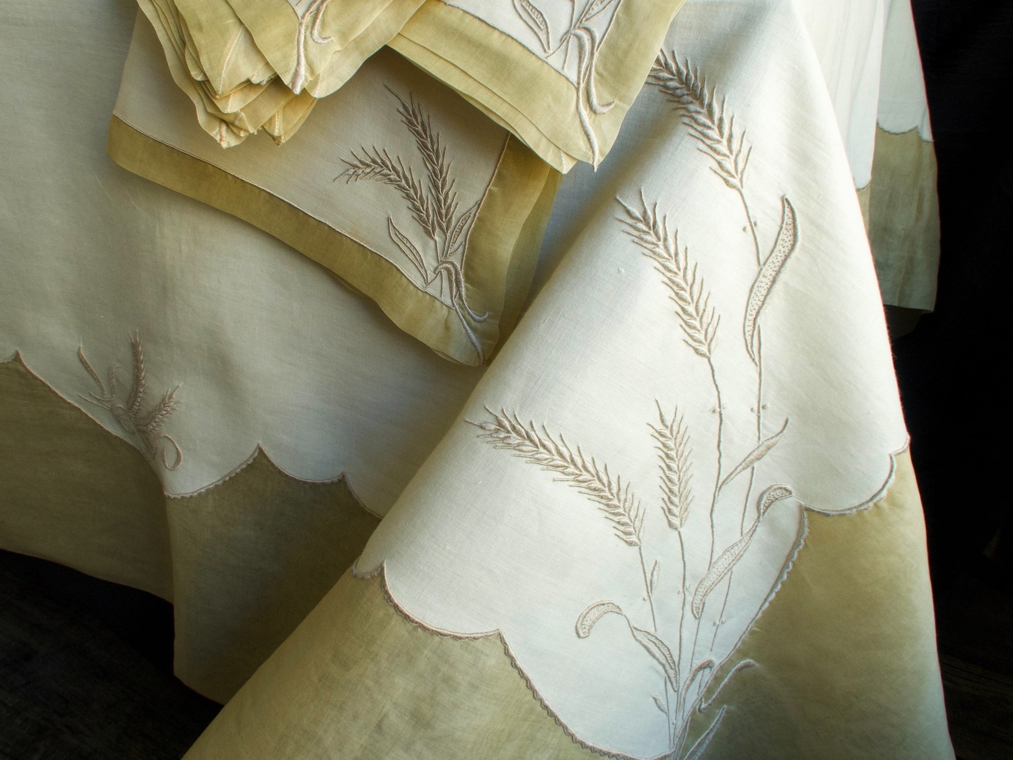 Marghab Wheat tablecloth hand-embroidered in Madeira, showing graceful wheat motifs across fine linen.